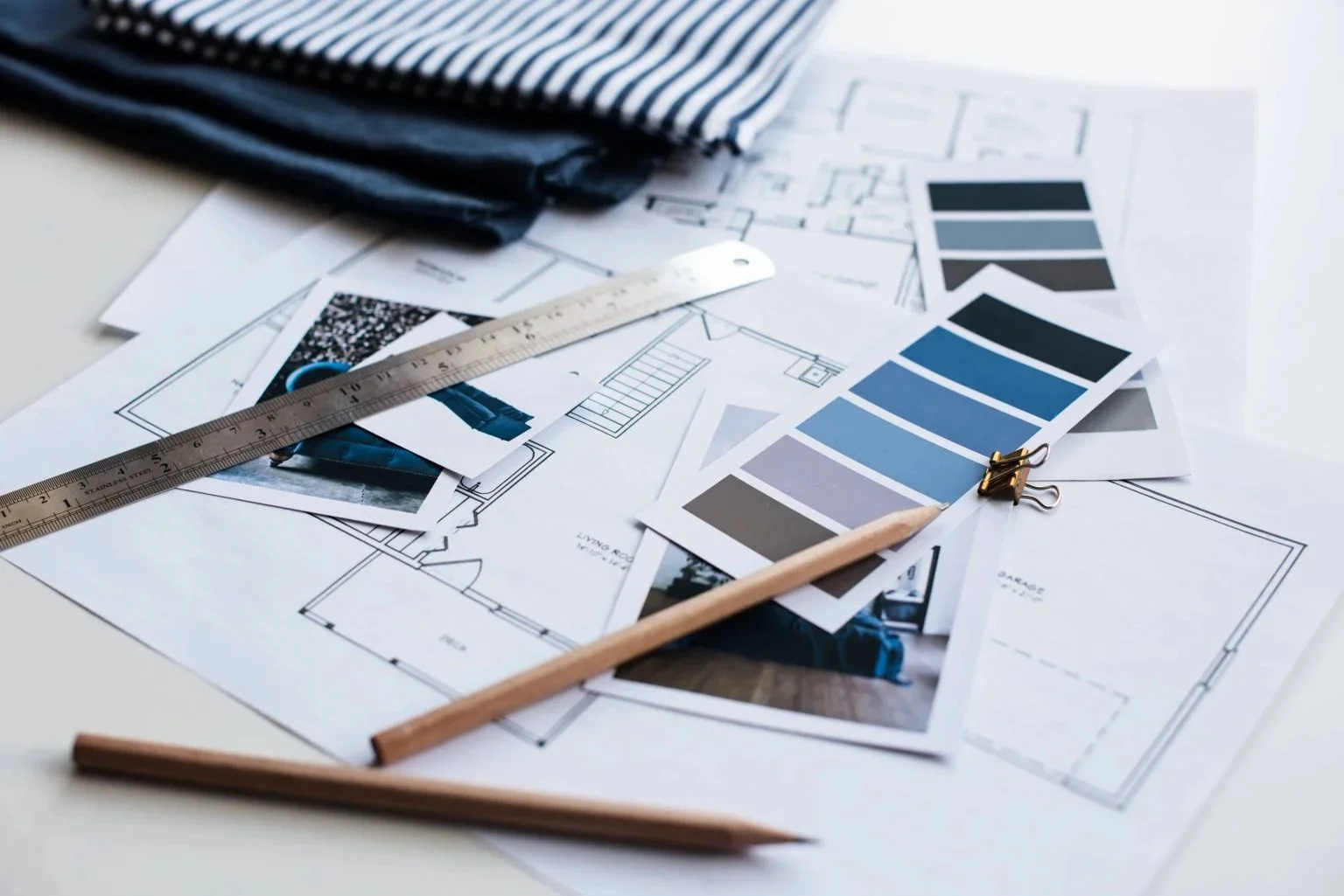 Paint colour swatch cards, floor plans, fabric samples and pencils laid out while a decorating scheme is planned