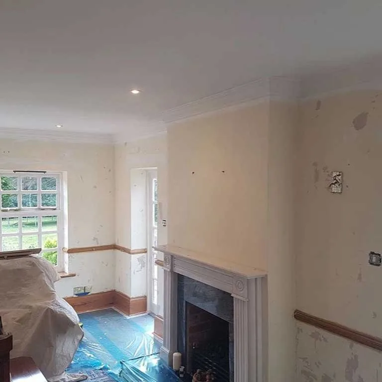 Living room walls prepped and sealed around a marble fireplace during interior decorating in Alton, Hampshire